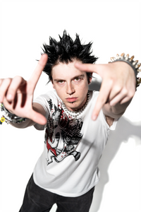 Person wearing a white t-shirt with a graphic design, making a gesture with their hands.