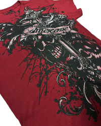 A close-up of a red graphic t-shirt featuring a large black and white tattoo-style design with a banner reading 'Mercense'.