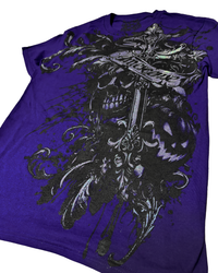A purple short-sleeve graphic t-shirt featuring a large gothic design of a skull, a sword, and a banner with the word 'AMESCENSE' printed on it.